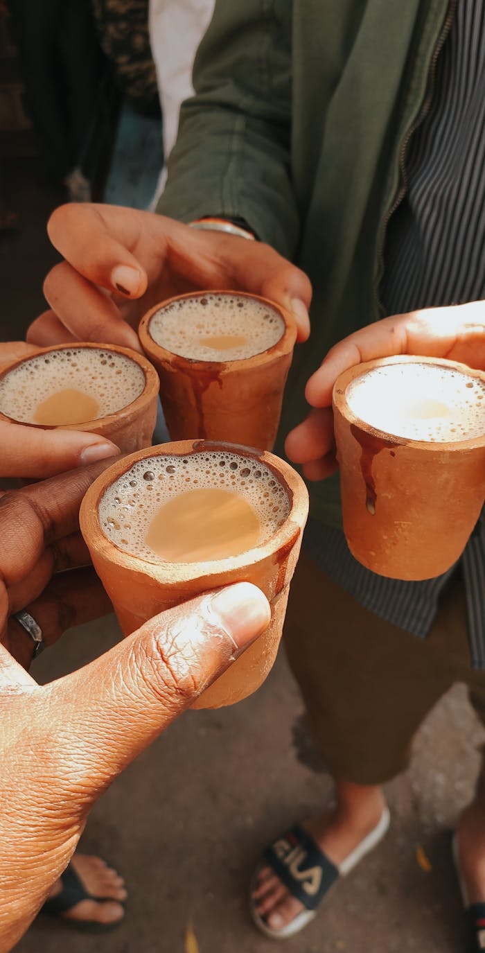 services-01 Friends toasting with traditional masala chai in clay cups, capturing a vibrant cultural moment.